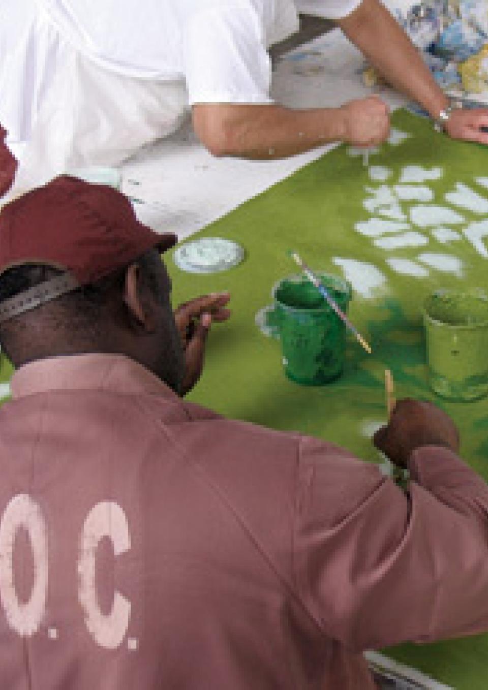 Poster for Concrete, Steel & Paint shows men in Department of Corrections outfits painting together.